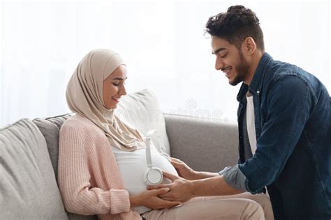 Caring Arab Husband Making Neck Massage To Pregnant Muslim Wife At Home Stock Image Image Of