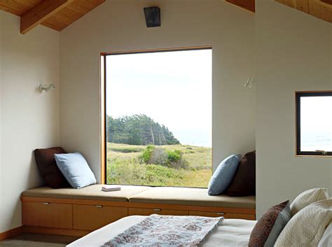 Seating arrangement under the long window and bed placed in the center of two windows of the rustic style bedroom is an amalgamation of rustic with modern setting. Window Seat Ideas for a Comfy Interior