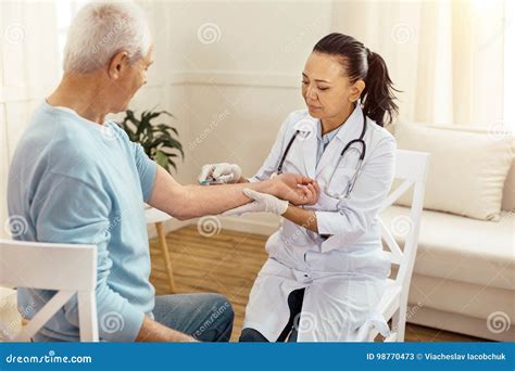 Professional Experienced Doctor Treating Her Patient Stock Image