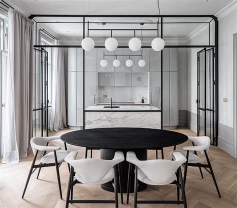 A Black Framed Glass Wall Separates The Kitchen From The Dining Room In