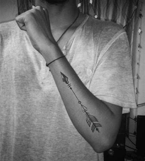 A Man With A Tattoo On His Arm And An Arrow In The Middle Of His Arm