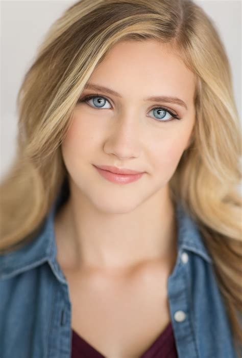 A Woman With Blonde Hair And Blue Eyes Is Posing For A Headshot In