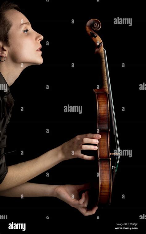 Woman Musician Holding Up A Classical Baroque Violin In Profile Over A