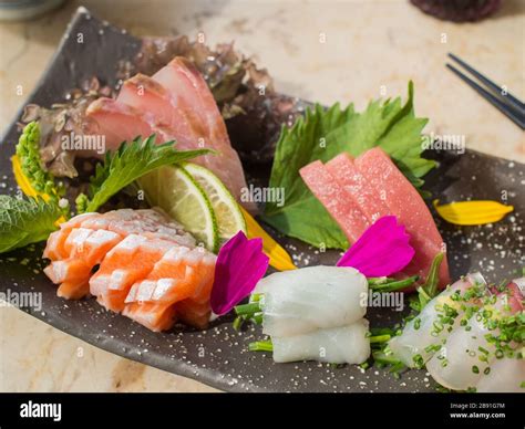 Japanese Raw Fish On Black Plate Also Known As Sashimi Stock Photo Alamy