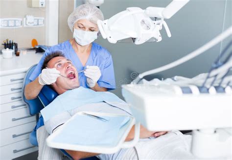 Female Dentist Treating Male Patient Stock Photo Image Of Dentistry