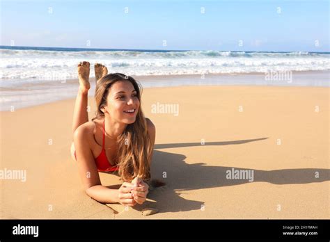 Smiling Beautiful Girl Lying Down On Sand Enjoying Sun Tanning Sunbathing In Swimsuit Relaxing