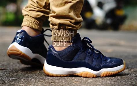 The sneakers use a brown and black colour scheme with a reversed nike logo. Air Jordan 11 Low Navy | Sole Collector