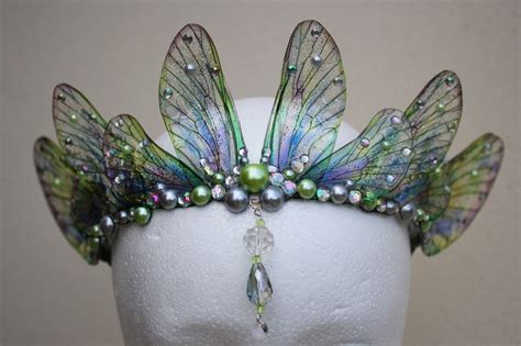 A White Headpiece With Green And Blue Wings
