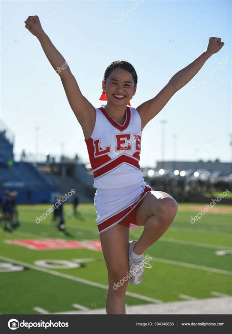 Cute Asian American Cheerleader Performing High School Football Game