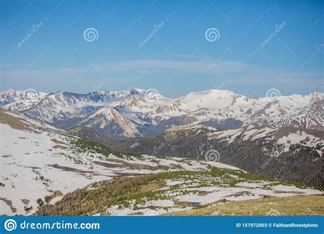 Green Meadow And Snowy Mountains On A Summer Day In Rocky Mountain