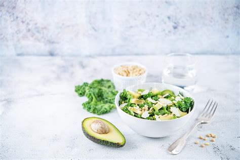 Kale Avocado Pine Nuts Cheese Salad With Lemon Dressing In A Bowl Stock