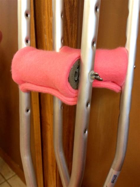 A Pink Towel Hanging On The Side Of A Wooden Door With Two Metal Bars