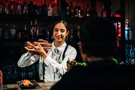Cheerful Bartender Mixing Cocktail Near Client By Stocksy Contributor David Prado Stocksy