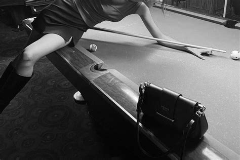 A Woman Leaning Over The Edge Of A Pool Table