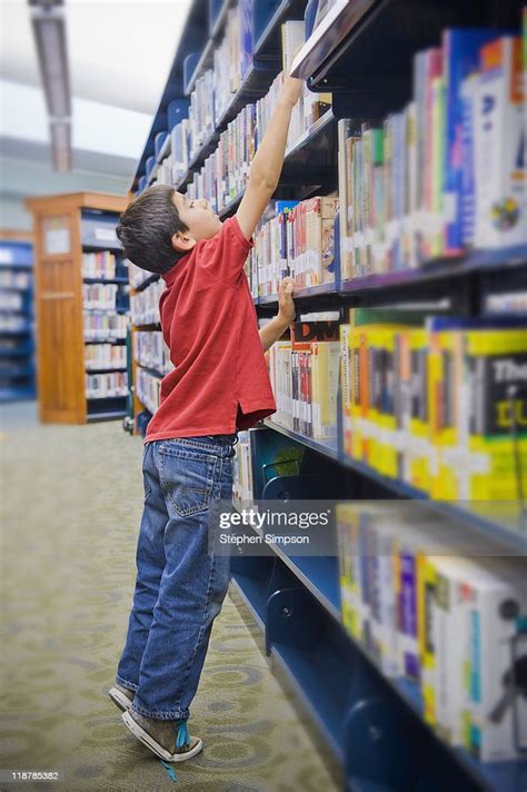 Boy Reaching High On Library Shelf High Res Stock Photo Getty Images