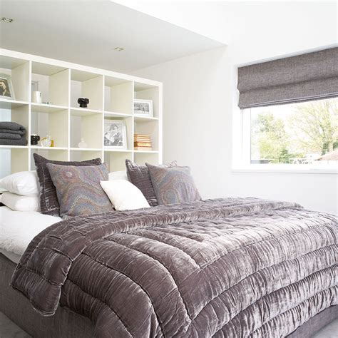 Purple and gray teen girl's bedroom features an accent wall clad in platinum gray grasscloth lined with a gray sunburst mirror over a white canopy bed dressed in purple floral bedding flanked by small mid century modern nightstands illuminated by french wall sconces alongside a pair of silver metallic faux python cube stools placed at the foot of the bed atop a gray shag rug. Grey bedroom ideas - grey bedroom decorating - grey colour ...