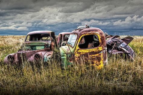 Scrapyard Of Old Trucks Abandoned In A Prairie Field Photograph By