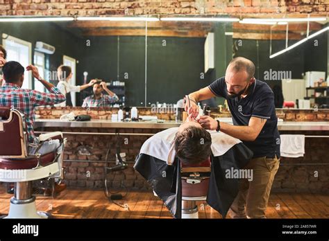 Male Barber Shaving Face Of Customer In Barbershop Stock Photo Alamy