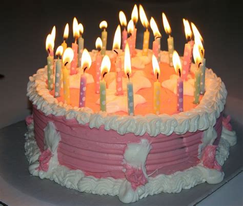 Pink Birthday Cake With White Cream And Lots Of Candles