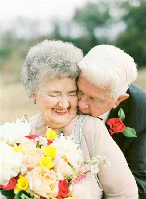 An Older Couple Embracing Each Other While Holding Flowers
