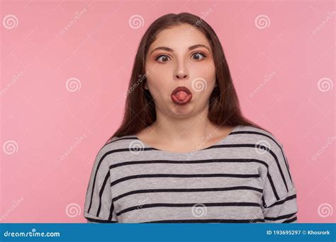 Portrait Of Funny Dumb Amusing Woman In Striped Sweatshirt Standing With Crossed Eyes Showing