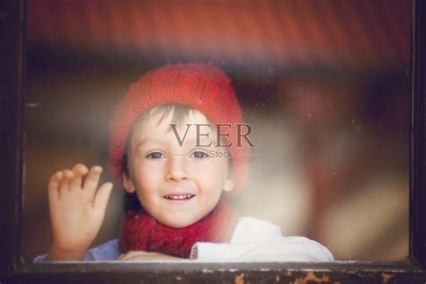 小男孩，窗户后面的孩子，戴着帽子和围巾照片摄影图片id165446993 Veer图库