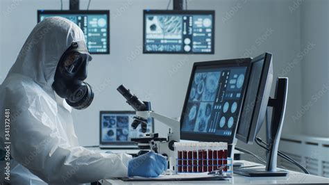 Scientist In Protection Suit And Masks Working In Research Lab Using