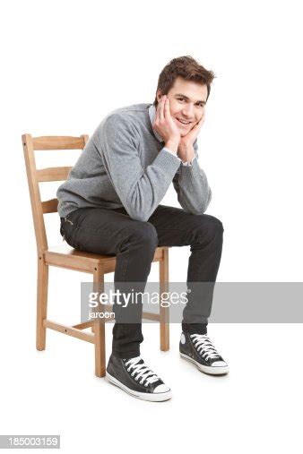 若いハンサムな男の灰色のセーターの椅子に座る ストックフォト Getty Images