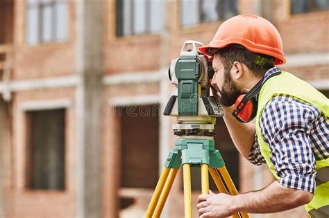 Geodetic Engineer Surveyor In White Hard Hat Doing Measurements With