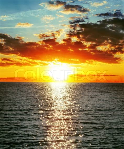 Red Sunset Over Water With Waves Stock Photo Colourbox