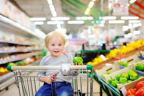 Toddler Boy Sitting In The Shopping Cart In A Supermarket Stock Photo