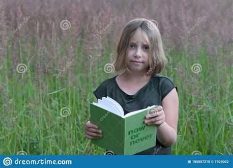 Little Girl Is Reading A Book Outside Stock Image Image Of Meadow