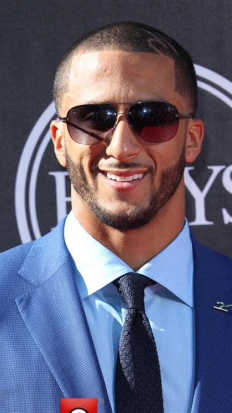 a man in a blue suit and tie smiling for the camera with sunglasses on his head