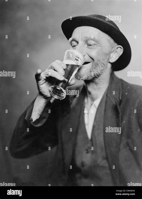 Happy Old Man Drinking Glass Of Beer With His Daintier Finger Extended