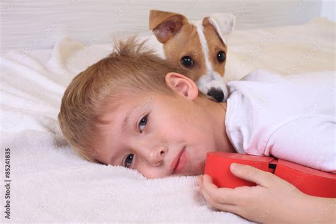 Young Boy Hugging His Dog In Bed Stock Foto Adobe Stock