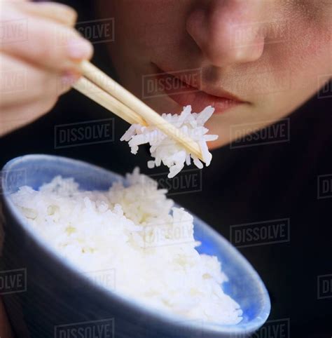 Many of us might think of chopsticks as predating cutlery, but historically around this time, rice also took its place as a staple in chinese dining. A Person Eating Rice with Chopsticks - Stock Photo - Dissolve