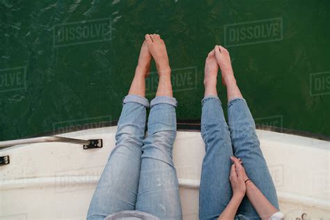 Two Women Relaxing On Boat Feet Over Edge Of Boat Barefoot Overhead