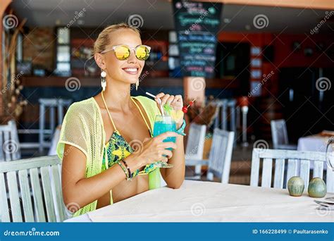 Summer Portrait Of A Beautiful Blonde Woman Drinking Cocktail In An Outdoor Beach Bar Stock