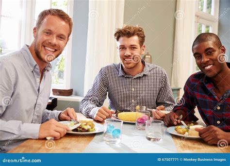 Male Friends At Home Sitting Around Table For Dinner Party Stock Image