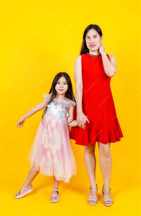 Premium Photo Asian Mom And Daughter Taking Portrait Photo Together On Yellow Background With