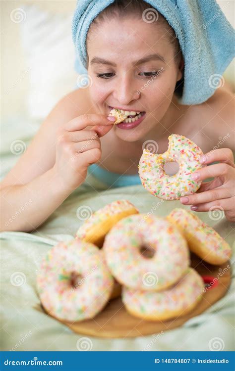 The Girl In A Towel Has Breakfast In The Bed A Young Attractive Woman Eats Donuts In Bed Stock