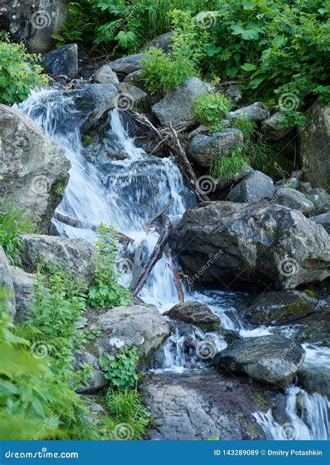 A Powerful Mountain Stream Flows Down From The Rocks And Stones Stock
