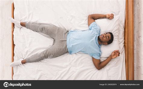 Young African American Man Sleeping In Bed Top View Stock Photo By