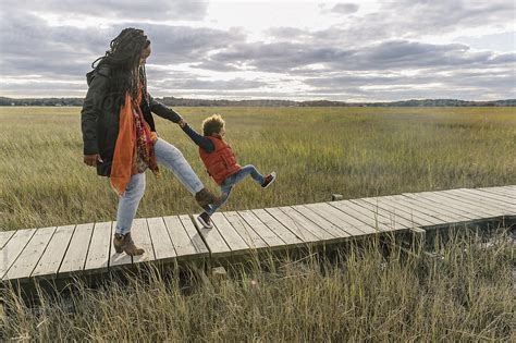 Black Mother Walking With Her Son On Boardwalk By Raymond Forbes Llc