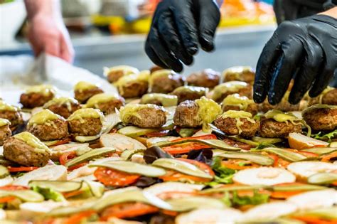 Portrait of curious female model licking lollipop. Female And Male Chef Putting Ingredients Of Burgers On A ...