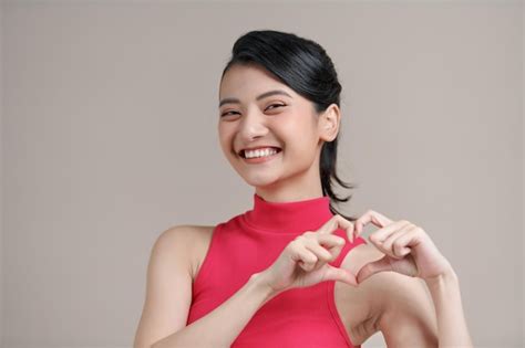 Premium Photo Pretty Romantic Young Asian Woman Making A Heart
