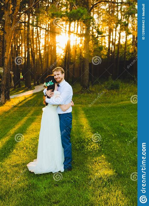 Couple Of Newlyweds Standing On A Green Grass Stock Photo Image Of