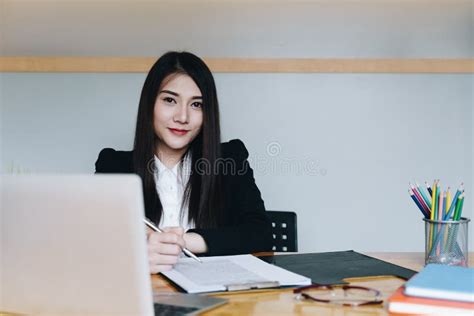 Beautiful Young Businesswoman Sitting At Desk In Front Of Laptop And