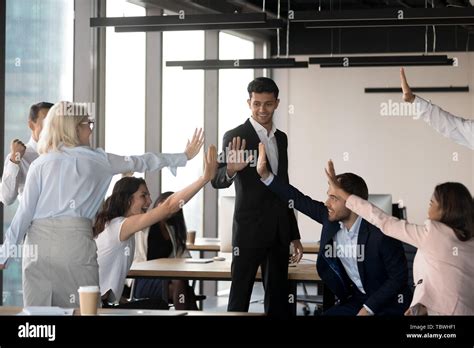 Excited Team Give High Five Celebrating Shared Success In Office Stock