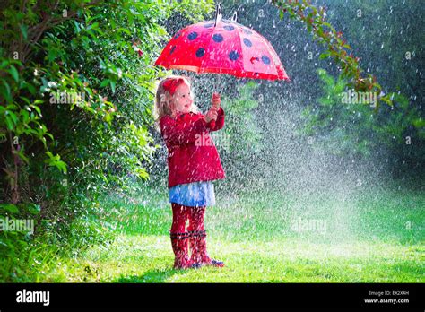 Little Girl With Red Umbrella Playing In The Rain Kids Play Outdoors